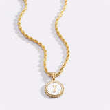 Necklace with a letter on a mother-of-pearl disk on a braided chain