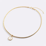 Necklace with a letter on a mother-of-pearl disk on a braided chain