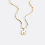 Necklace with a letter on a mother-of-pearl disk on a braided chain