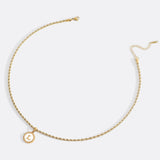 Necklace with a letter on a mother-of-pearl disk on a braided chain