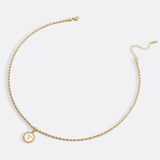 Necklace with a letter on a mother-of-pearl disk on a braided chain