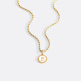 Necklace with a letter on a mother-of-pearl disk on a braided chain