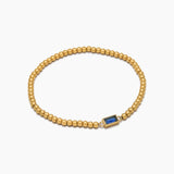 Golden beaded bracelet with a birthstone