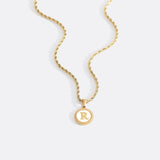 Necklace with a letter on a mother-of-pearl disk on a braided chain