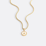 Necklace with a letter on a mother-of-pearl disk on a braided chain