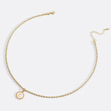 Necklace with a letter on a mother-of-pearl disk on a braided chain