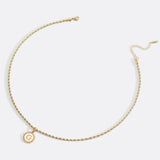 Necklace with a letter on a mother-of-pearl disk on a braided chain