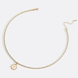 Necklace with a letter on a mother-of-pearl disk on a braided chain