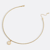Necklace with a letter on a mother-of-pearl disk on a braided chain