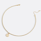 Necklace with a letter on a mother-of-pearl disk on a braided chain