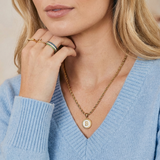 Necklace with a letter on a mother-of-pearl disk on a braided chain